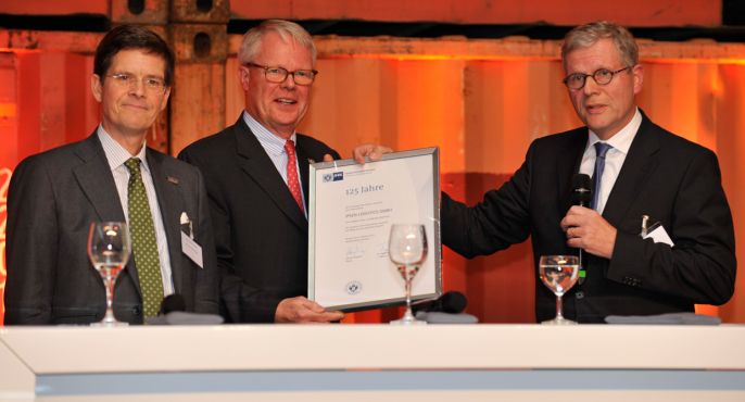 Harald Emigholz (rechts außen), Präses der IHK Bremen/Bremerhaven, überreicht den Geschäftsführenden Gesellschaftern  Hans-Christian Specht und Eduard Dubbers-